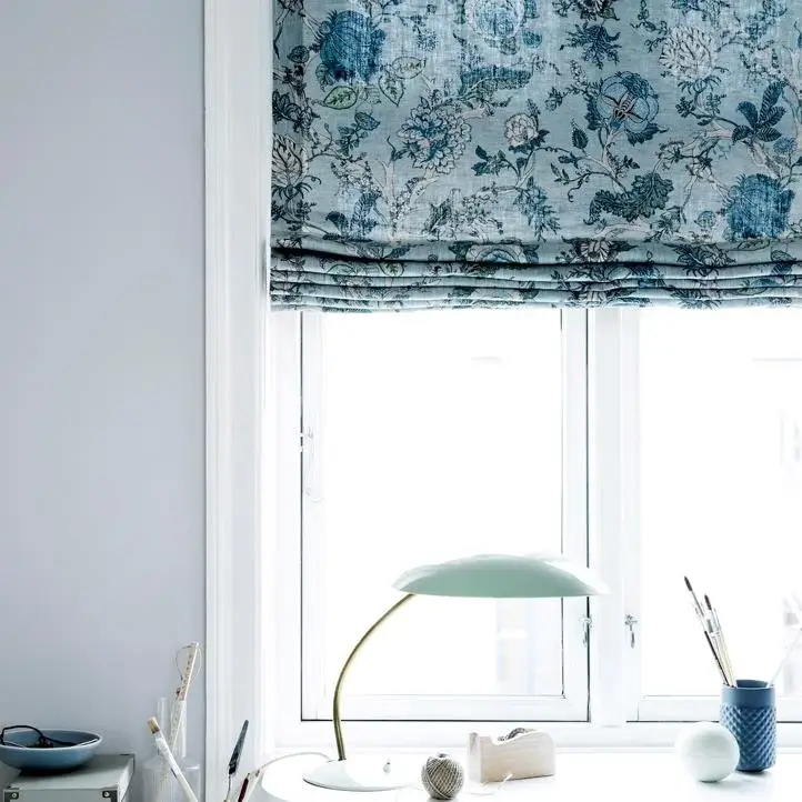 Blomstret rullegardin over skrivebord med lampe