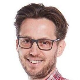 Smiling man wearing glasses and plaid shirt